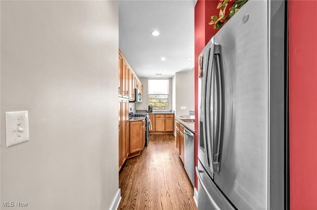 11901 Detroit Ave, Lakewood, OH 44107 - kitchen featuring appliances with stainless steel finishes, wood finished floors, recessed lighting, and brown cabinetry