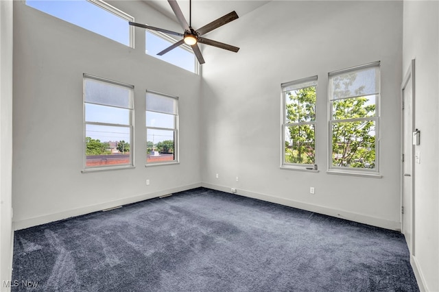 11901 Detroit Ave, Lakewood, OH 44107 - unfurnished room with dark colored carpet, a ceiling fan, plenty of natural light, and a towering ceiling