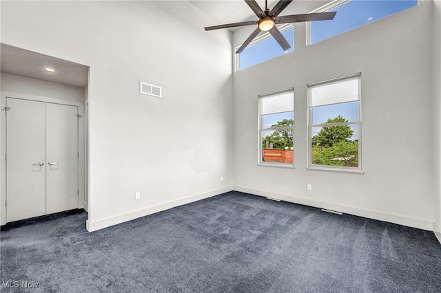 11901 Detroit Ave, Lakewood, OH 44107 - unfurnished bedroom featuring dark carpet, a towering ceiling, ceiling fan, and recessed lighting
