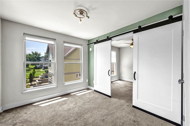 11901 Detroit Ave, Lakewood, OH 44107 - carpeted spare room featuring a barn door and baseboards