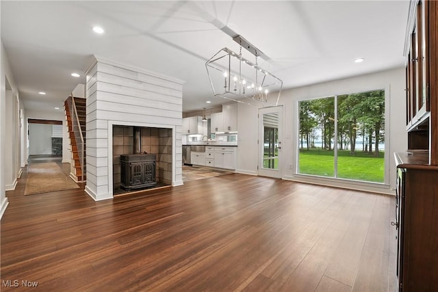 263 E Pne Lake Rd, North Lima, OH 44452 - unfurnished living room featuring a wood stove, dark wood-style floors, recessed lighting, and a chandelier