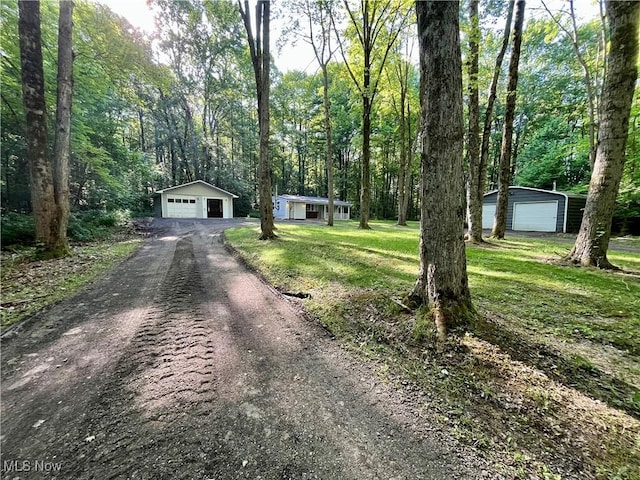 4807 Laskey Rd, Rome, OH 44085 - view of front of home with a detached garage, an outbuilding, a front yard, and a view of trees