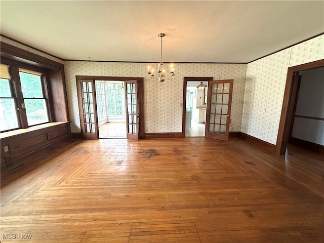 1709 Washington Blvd, Belpre, OH 45714 - unfurnished dining area with wallpapered walls, french doors, healthy amount of natural light, a chandelier, and ornamental molding