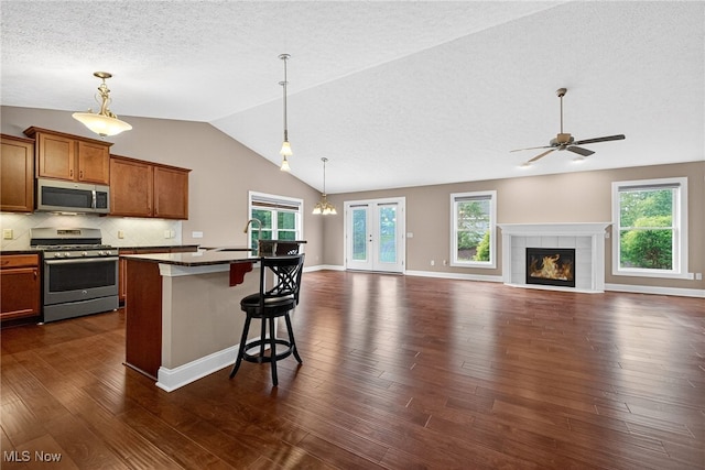 498 Water Pointe Ln, Brunswick, OH 44212 - kitchen featuring stainless steel appliances, lofted ceiling, dark countertops, ceiling fan, and brown cabinets