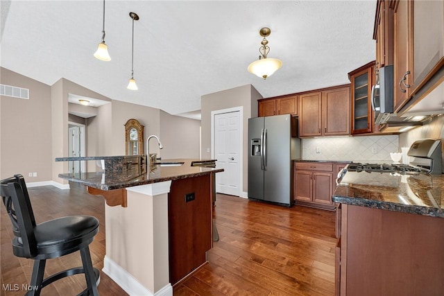 498 Water Pointe Ln, Brunswick, OH 44212 - kitchen with appliances with stainless steel finishes, dark wood finished floors, brown cabinetry, and decorative backsplash