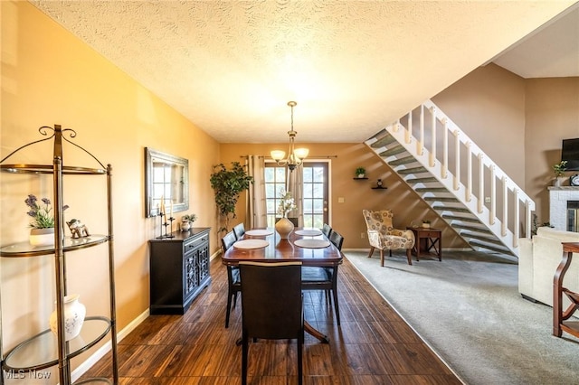 1870 E 223rd St, Euclid, OH 44117 - dining space featuring a chandelier, stairs, a textured ceiling, and a brick fireplace