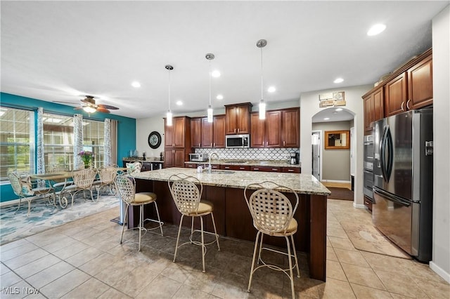 8028 Megan Meadow Dr, Hudson, OH 44236 - kitchen with appliances with stainless steel finishes, light tile patterned floors, light stone counters, a kitchen bar, and recessed lighting