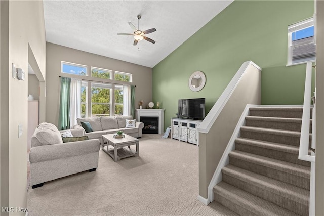 866 Brightwood Ct, Brunswick, OH 44212 - carpeted living room featuring a ceiling fan, stairs, high vaulted ceiling, and a glass covered fireplace