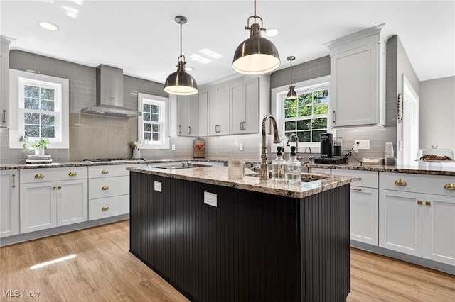14370 Washington Blvd, University Heights, OH 44118 - kitchen featuring wall chimney range hood, decorative backsplash, an island with sink, healthy amount of natural light, and recessed lighting