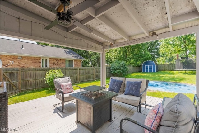 4950 Trafalgar St SW, Canton, OH 44706 - deck featuring a fenced backyard, a storage unit, a trampoline, an outdoor hangout area, and ceiling fan