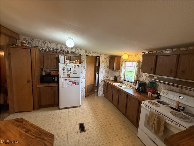 44534 US Highway 36, Coshocton, OH 43812 - kitchen with white appliances, wallpapered walls, light floors, and extractor fan