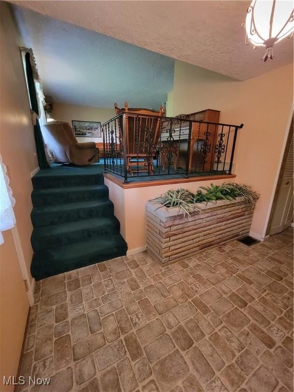 5622 Donna Dr, Ashtabula, OH 44004 - stairway with brick patterned floors and a textured ceiling