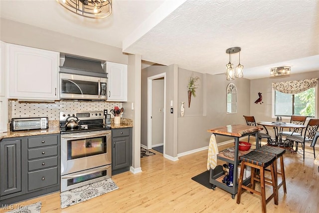7148 N Brewster Pl, Concord, OH 44077 - kitchen featuring appliances with stainless steel finishes, gray cabinetry, white cabinetry, light wood finished floors, and a textured ceiling