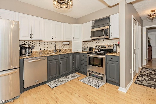 7148 N Brewster Pl, Concord, OH 44077 - kitchen with stainless steel appliances, gray cabinetry, light wood-type flooring, and white cabinetry