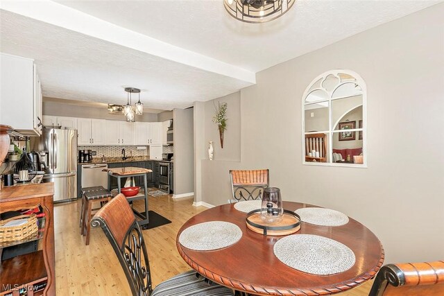 7148 N Brewster Pl, Concord, OH 44077 - dining area with light wood finished floors and a chandelier