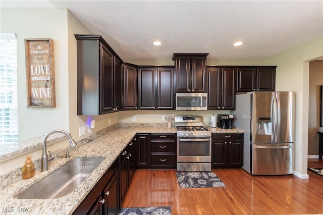 3139 Junior Pkwy, Brunswick, OH 44212 - kitchen featuring appliances with stainless steel finishes, light wood-type flooring, dark brown cabinetry, light stone counters, and recessed lighting