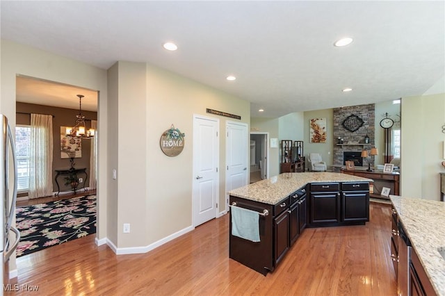 3139 Junior Pkwy, Brunswick, OH 44212 - kitchen with light wood-style flooring, a fireplace, a chandelier, open floor plan, and healthy amount of natural light