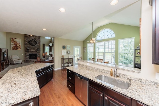 3139 Junior Pkwy, Brunswick, OH 44212 - kitchen with dishwasher, open floor plan, a stone fireplace, lofted ceiling, and light wood-style flooring