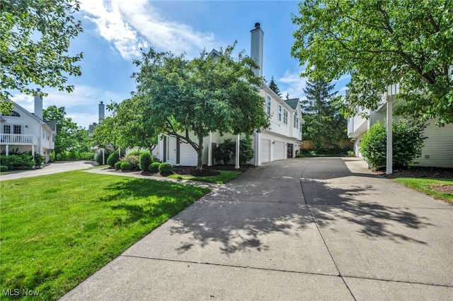 254 Vista Cir, North Olmsted, OH 44070 - view of front of house with a garage, concrete driveway, a front lawn, and a chimney