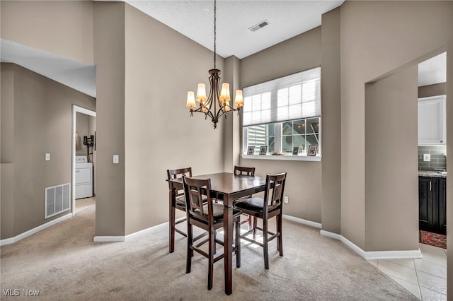 254 Vista Cir, North Olmsted, OH 44070 - dining space with washer / dryer, a chandelier, light carpet, and high vaulted ceiling