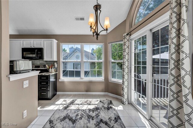 254 Vista Cir, North Olmsted, OH 44070 - kitchen with black microwave, light tile patterned floors, plenty of natural light, white cabinets, and lofted ceiling