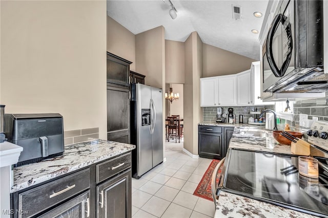 254 Vista Cir, North Olmsted, OH 44070 - kitchen featuring black appliances, light stone countertops, tasteful backsplash, light tile patterned floors, and a chandelier