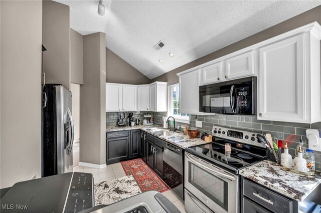 254 Vista Cir, North Olmsted, OH 44070 - kitchen featuring black appliances, white cabinetry, lofted ceiling, light tile patterned floors, and decorative backsplash