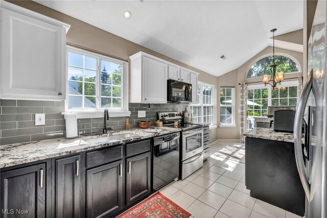254 Vista Cir, North Olmsted, OH 44070 - kitchen with black appliances, light tile patterned floors, white cabinetry, vaulted ceiling, and tasteful backsplash