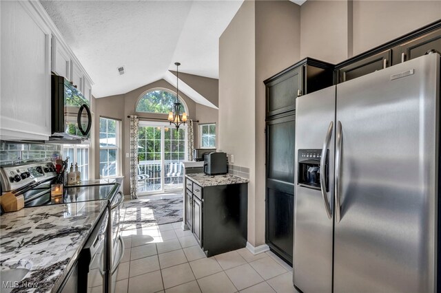 254 Vista Cir, North Olmsted, OH 44070 - kitchen with stainless steel appliances, a chandelier, lofted ceiling, light stone counters, and light tile patterned floors