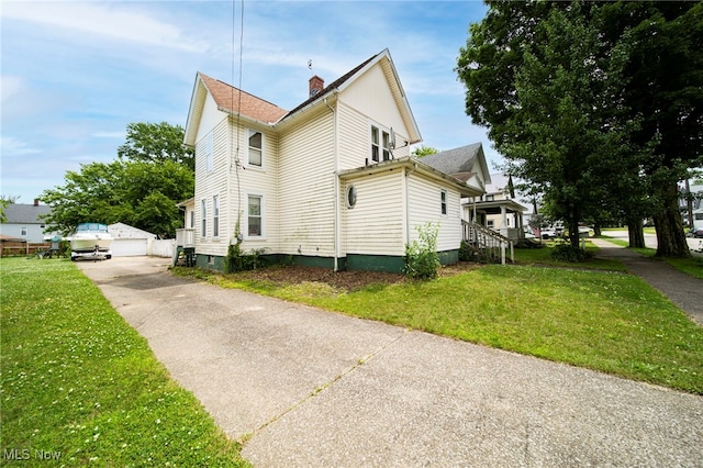 238 Whitney St, Conneaut, OH 44030 - view of property exterior featuring an outbuilding, a lawn, a chimney, and a garage