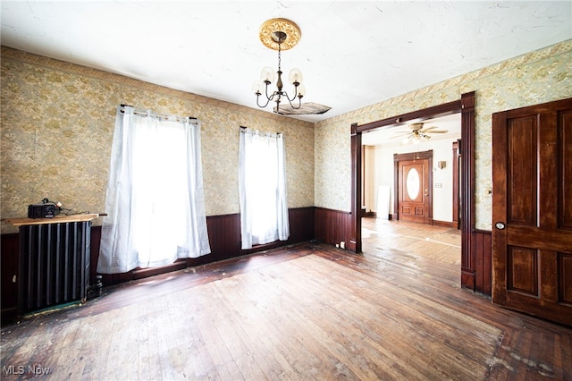 238 Whitney St, Conneaut, OH 44030 - unfurnished dining area featuring radiator, wainscoting, a chandelier, wallpapered walls, and hardwood / wood-style floors