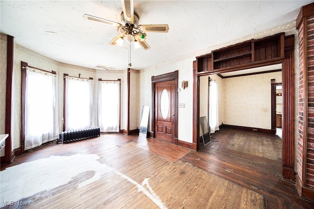 238 Whitney St, Conneaut, OH 44030 - foyer with radiator heating unit, a ceiling fan, and wood-type flooring