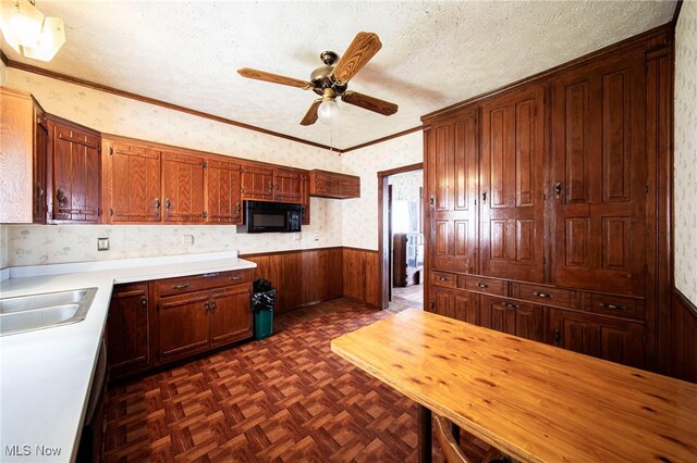 238 Whitney St, Conneaut, OH 44030 - kitchen featuring black microwave, wainscoting, a ceiling fan, light countertops, and wallpapered walls