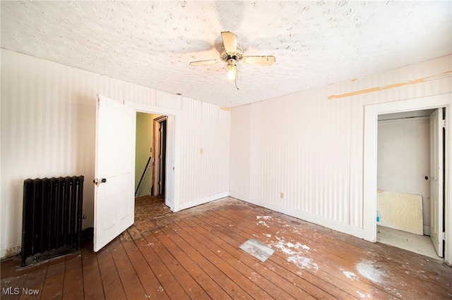 238 Whitney St, Conneaut, OH 44030 - spare room featuring radiator heating unit, hardwood / wood-style flooring, a textured ceiling, and ceiling fan