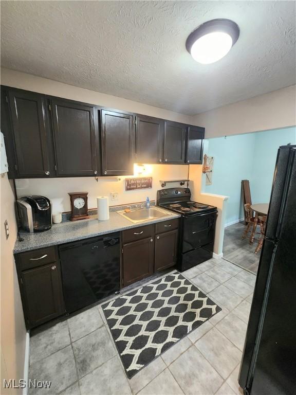 4211 Dennis Ln, Brunswick, OH 44212 - kitchen with black appliances, light tile patterned floors, light countertops, and a textured ceiling