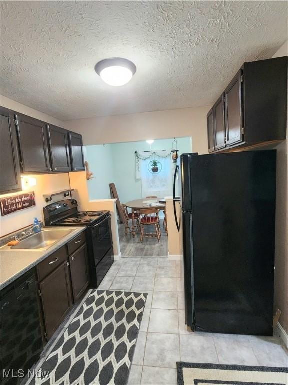 4211 Dennis Ln, Brunswick, OH 44212 - kitchen featuring black appliances, a textured ceiling, light tile patterned floors, and light countertops
