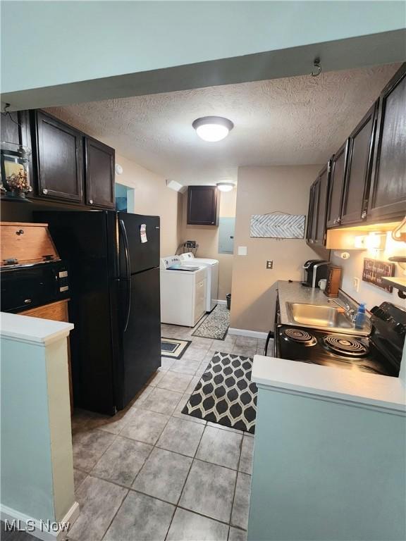 4211 Dennis Ln, Brunswick, OH 44212 - kitchen featuring washing machine and clothes dryer, a textured ceiling, light tile patterned floors, freestanding refrigerator, and light countertops