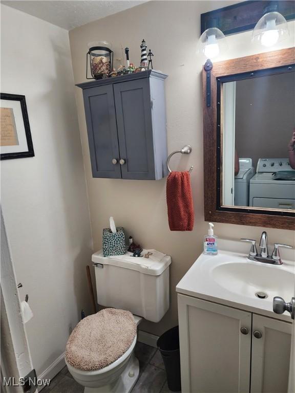 4211 Dennis Ln, Brunswick, OH 44212 - bathroom with washing machine and dryer, vanity, and tile patterned floors