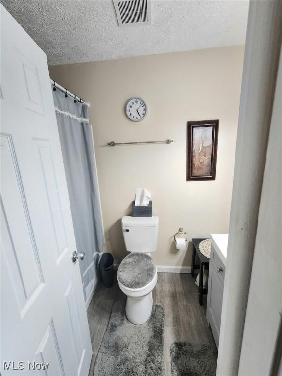 4211 Dennis Ln, Brunswick, OH 44212 - full bathroom with vanity, wood finished floors, and a textured ceiling
