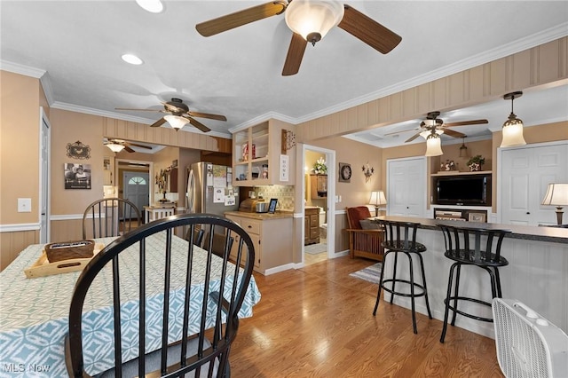 4843 Summer Ln, Brooklyn, OH 44144 - dining area featuring ceiling fan, crown molding, light wood-type flooring, and wainscoting