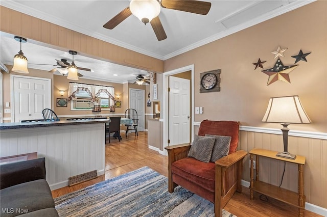 4843 Summer Ln, Brooklyn, OH 44144 - living room with light wood-style flooring, ceiling fan, ornamental molding, and a wainscoted wall