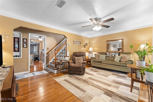4843 Summer Ln, Brooklyn, OH 44144 - living room with a ceiling fan, stairway, light wood-type flooring, arched walkways, and a textured ceiling