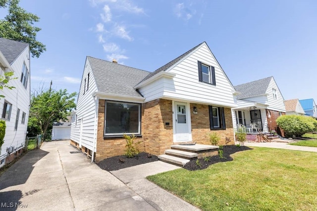 4033 Stonehaven Rd, South Euclid, OH 44121 - view of front facade with roof with shingles, a front yard, brick siding, an outdoor structure, and a garage