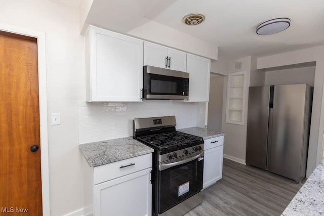 4033 Stonehaven Rd, South Euclid, OH 44121 - kitchen with appliances with stainless steel finishes, light wood-style flooring, white cabinetry, tasteful backsplash, and light stone counters