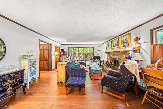 278 Rosewae Ave, Cortland, OH 44410 - living room featuring ornamental molding, light wood finished floors, a textured ceiling, plenty of natural light, and a brick fireplace