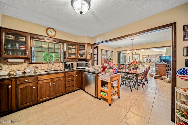 278 Rosewae Ave, Cortland, OH 44410 - kitchen featuring stainless steel appliances, a textured ceiling, decorative backsplash, glass insert cabinets, and a chandelier
