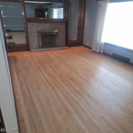 726 Orlo Ln, Boardman, OH 44512 - unfurnished living room with a brick fireplace and wood finished floors