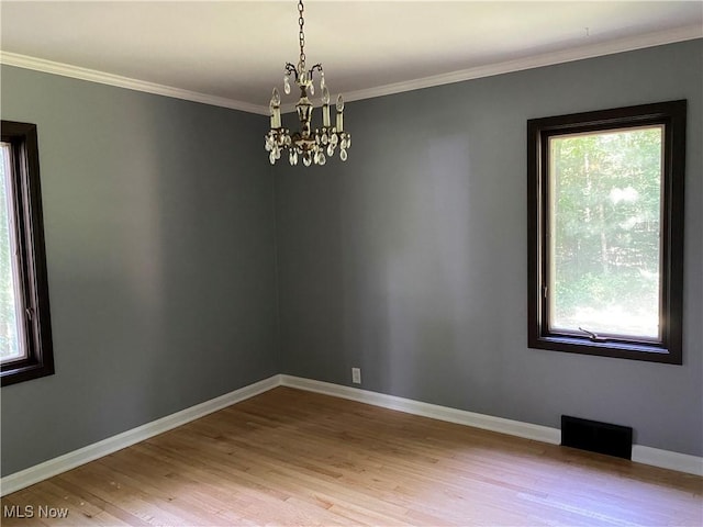 726 Orlo Ln, Boardman, OH 44512 - unfurnished room featuring plenty of natural light, a chandelier, wood finished floors, and ornamental molding