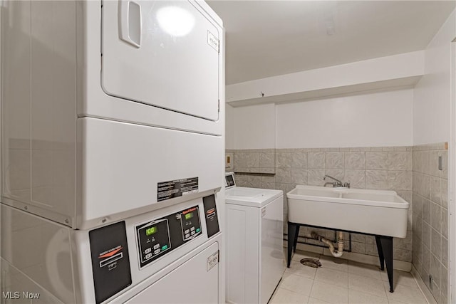 19201 Van Aken Blvd Unit 211, Shaker Heights, OH 44122 - community laundry room featuring stacked washer / dryer, light tile patterned floors, and tile walls