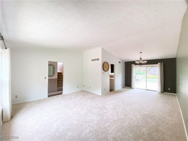 123 Prentiss St, Munroe Falls, OH 44262 - unfurnished living room featuring a chandelier, lofted ceiling, light carpet, stairs, and a textured ceiling